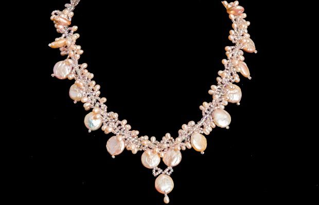 A necklace with pearls and crystals on it.