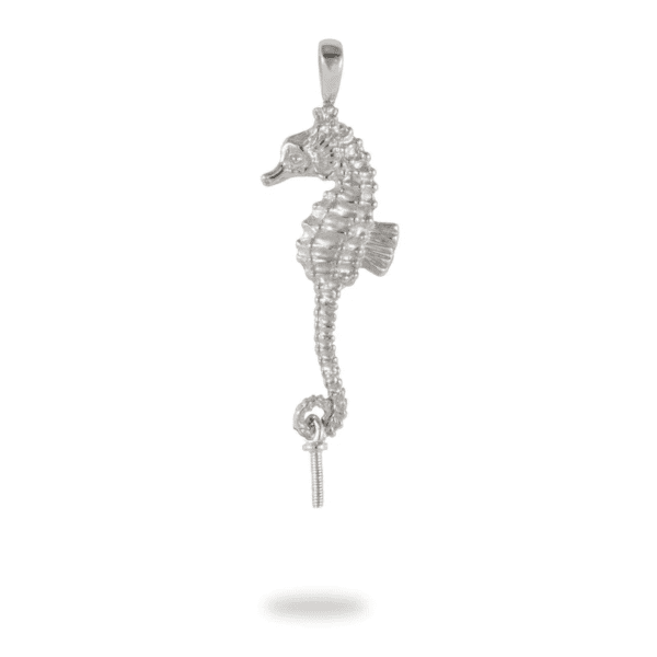 A silver seahorse with white stones hanging from it's tail.