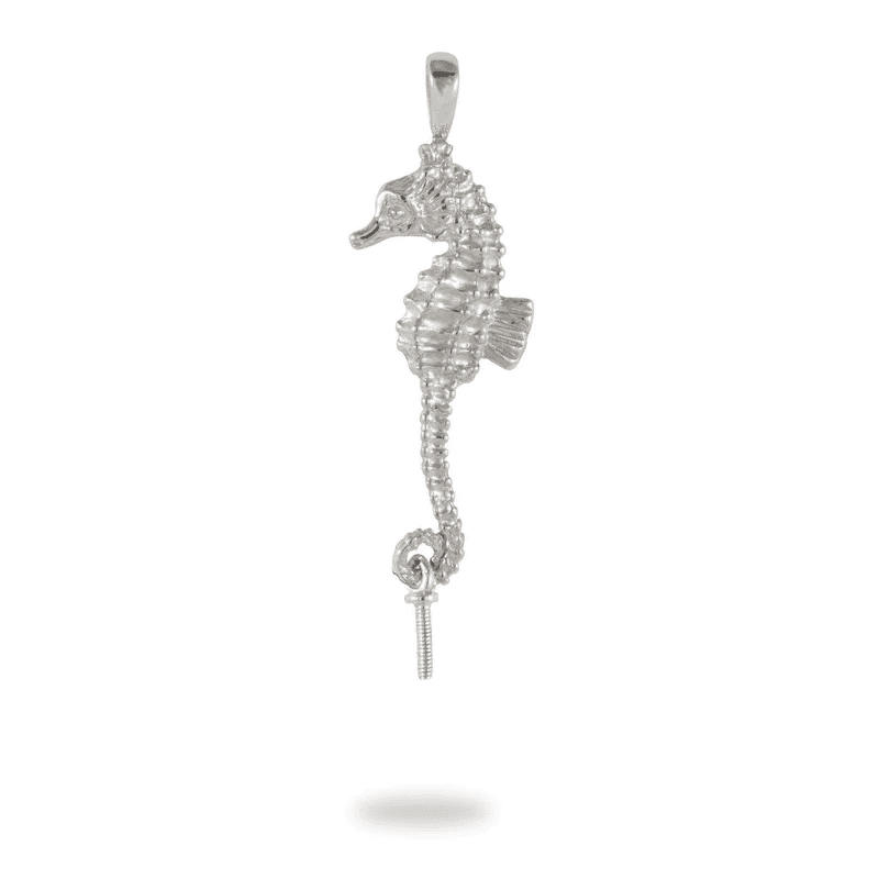 A silver seahorse with white stones hanging from it's tail.